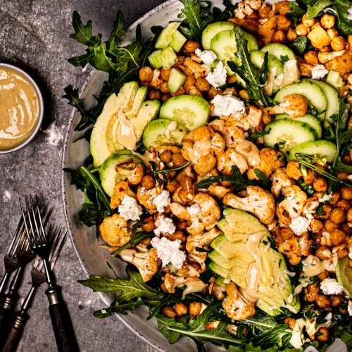 Gerösteter Blumenkohlsalat mit Kichererbsen, Avocado, Gurke, Feta und Honig-Senf-Dressing #blumenkohl #ofengericht #kichererbsen #vegetarischerezepte #veggie #vegan #salat #kichererbsensalat #blumenkohlsalat