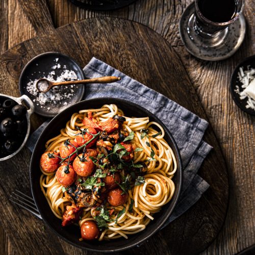 Spaghetti alla Puttanesca ist ein einfacher italienischer Pasta Klassiker mit Tomate, Oliven, Sardellen, Kapern und Chili – so einfach geht's!